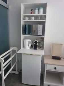 a small kitchen with a white counter and a table at 12onParkesLane in Knysna