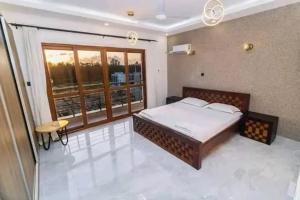 a bedroom with a bed and a large window at Turkana Flat apartment in Nakuru