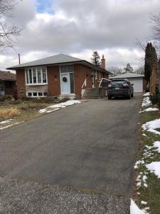 a house with a car parked in the driveway at Premium home with Garden view, private parking in Toronto