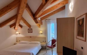 1 dormitorio con 1 cama, 1 silla y 1 ventana en Villa Da Remo, en Tenna 