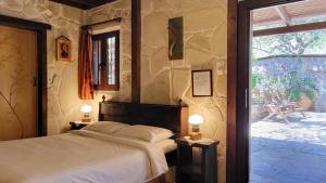 a bedroom with a bed and a large window at Studios Stella & Stella's Traditional in Kato Zakros