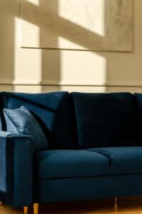 Un sofá azul en una sala de estar. en RentPlanet - Apartament Jana Pawła II, en Wroclaw