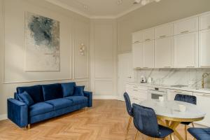 Una sala de estar con un sofá azul y una mesa. en RentPlanet - Apartament Jana Pawła II, en Wroclaw