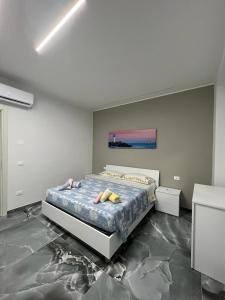 een slaapkamer met een bed en een schilderij aan de muur bij PMM HOUSE in Librizzi