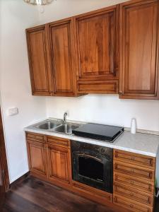 eine Küche mit Holzschränken und einem Waschbecken in der Unterkunft Casa d'Alunzio - Plesso Via Rebiba in San Marco dʼAlunzio