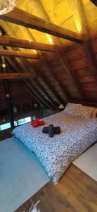 Bett in einem Zimmer mit Holzdecke in der Unterkunft CABAÑA VENTO NORTE in Vilamós