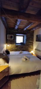 1 dormitorio con 1 cama grande en una habitación con ventana en CABAÑA VENTO NORTE, en Vilamòs