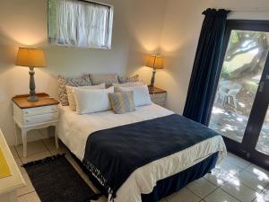 a bedroom with a bed and a large window at Anchor Drift in St Francis Bay