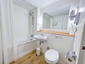 a bathroom with a sink and a toilet and a mirror at Kyriad Cannes - Mandelieu in Cannes