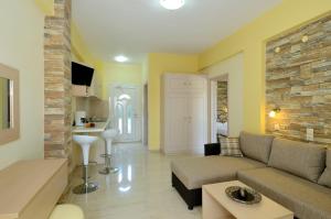 a living room with a couch and a stone wall at Albatros Studios & Apartments in Plakias