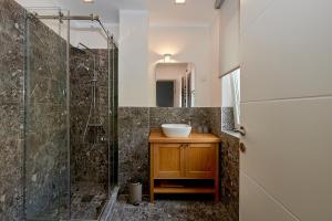 a bathroom with a sink and a glass shower at 2montenegro MIMOZA Apartments in Dobrota