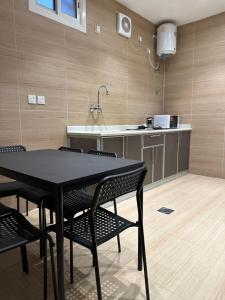 a kitchen with a table and chairs in a room at الأمان للشقق المخدومة Alamaan Serviced Apartments in Medina