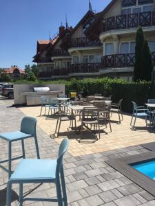 patio ze stołami i krzesłami przed budynkiem w obiekcie Lelle Marine Resort Voila Apartman w mieście Balatonlelle