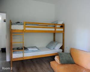 Quiet, green, relaxing place- 3 bedroom villa في بالاتونفوريد: سريرين بطابقين في غرفة مع أريكة