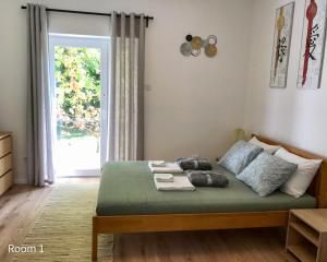 Quiet, green, relaxing place- 3 bedroom villa في بالاتونفوريد: غرفة نوم بسرير وباب مع نافذة