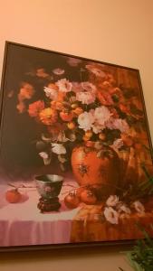 una pintura de un jarrón de flores en una mesa en Camera tip economic Mozart, en Cluj-Napoca