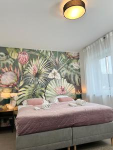 a bedroom with a large bed with a floral wallpaper at BnB Open Apartments Pader-Lounge in Paderborn