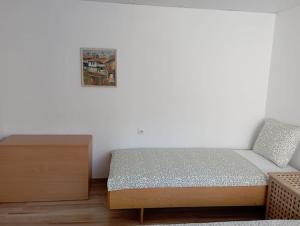 a small bedroom with a bed and a dresser at Gradina Apartment in Montana