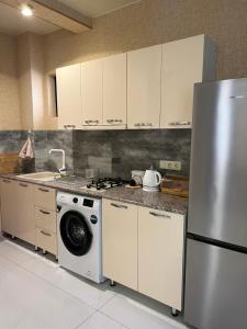 a kitchen with a refrigerator and a washing machine at villa with beautiful view 3 in Tbilisi City