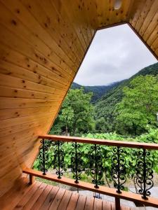 a view from a wooden balcony with a window at K&M Cottage in Borjomi