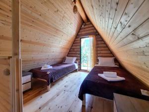 a room with two beds in a wooden cabin at K&M Cottage in Borjomi