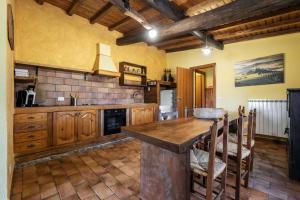 a large kitchen with wooden cabinets and a table at Sasso Bianco in Pitigliano