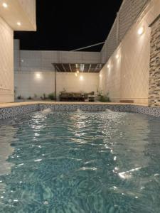 a swimming pool in a building with green water at شاليهات وجدان الهدا in Al Hada