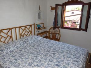 een slaapkamer met een bed met een blauwe deken bij Monolocale San Teodoro in San Teodoro