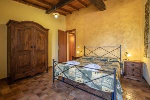 a bedroom with a bed and a wooden cabinet at Sasso Bianco in Pitigliano