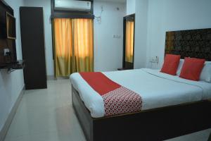a bedroom with a large bed with red pillows at HOTEL SHIVA in Guwahati