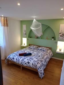 1 dormitorio con 1 cama con edredón blanco y negro en Villa de charme, en Saint-Coutant-le-Grand