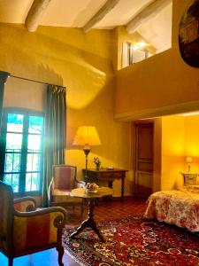 リル・シュル・ラ・ソルギュにあるMaison d'hôtes Campagne-Baudeloupのベッドルーム1室(ベッド1台、テーブル、椅子付)