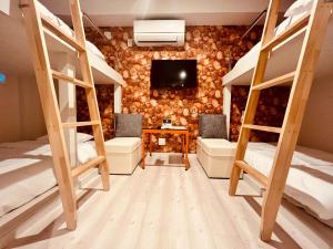 a room with four bunk beds and a tv at GRAND CAVE MOTOMACHI in Yokohama