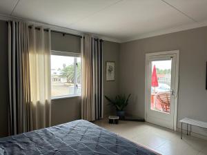 a bedroom with a bed and a large window at 19 Richthofen in Swakopmund +37 photos