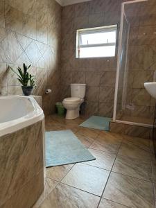 a bathroom with a tub and a toilet and a sink at 19 Richthofen in Swakopmund