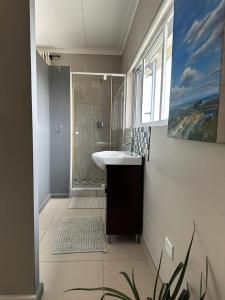 uma casa de banho com um lavatório e um chuveiro em 19 Richthofen em Swakopmund
