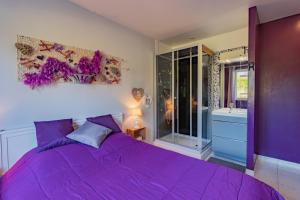 a purple bedroom with a large bed and a tub at Petit coin de paradis Périgourdin in Montrem