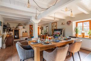 的住宿－Chez Maïdi : Authenticité, Confort et Nature，用餐室以及带木桌和椅子的客厅。