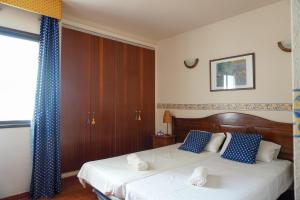 a bedroom with two beds with blue and white pillows at Beach Breeze, Playa Santiago in Alajeró