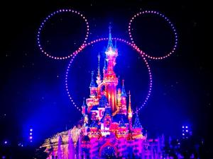 a disney castle lit up at night at Appt Vue Parc Disneyland-PARIS - Terrasse - Parking Privé in Chessy +42 photos