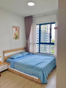 a bedroom with a blue bed and a window at Căn hộ 2pn2wc Celadon City Aeon Mall Tân Phú in Ho Chi Minh City