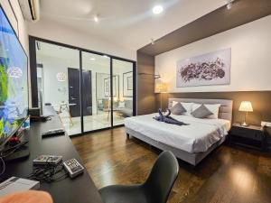 Almas Suite by Nest Home【Puteri Harbour & LEGOLAND】 في نوساجايا: غرفة نوم مع سرير كبير ومكتب مع كرسي