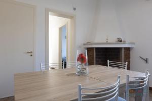 Casa vacanza Lucia Puglia On line في مورتشانو دي ليوكا: طاولة غرفة طعام مع مزهرية مع وردة حمراء فيها