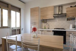 Casa vacanza Lucia Puglia On line في مورتشانو دي ليوكا: مطبخ مع طاولة خشبية مع كراسي وطاولة مطبخ