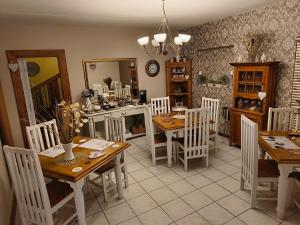 a kitchen and dining room with wooden tables and chairs at La Bohéme Gastehuis in Bloemfontein