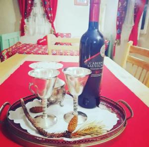 a bottle of wine and two wine glasses on a table at Vikendica Nada in Ljubovija