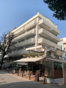 リミニにあるCasa Parco del Mareのテーブルと椅子が前に置かれた大きな建物