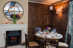 a dining room with a table and a fireplace at The White Hart, Overton in Overton