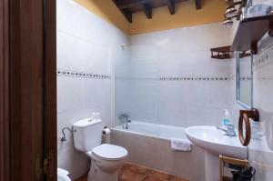 a bathroom with a toilet and a tub and a sink at Casa La Aldea de Guadamia in Llames de Pría +31 photos