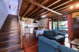 a living room with two blue chairs and a table at Casa La Aldea de Guadamia in Llames de Pría